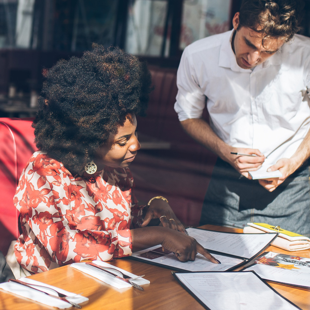 Une dame qui passe sa commande dans une brasserie