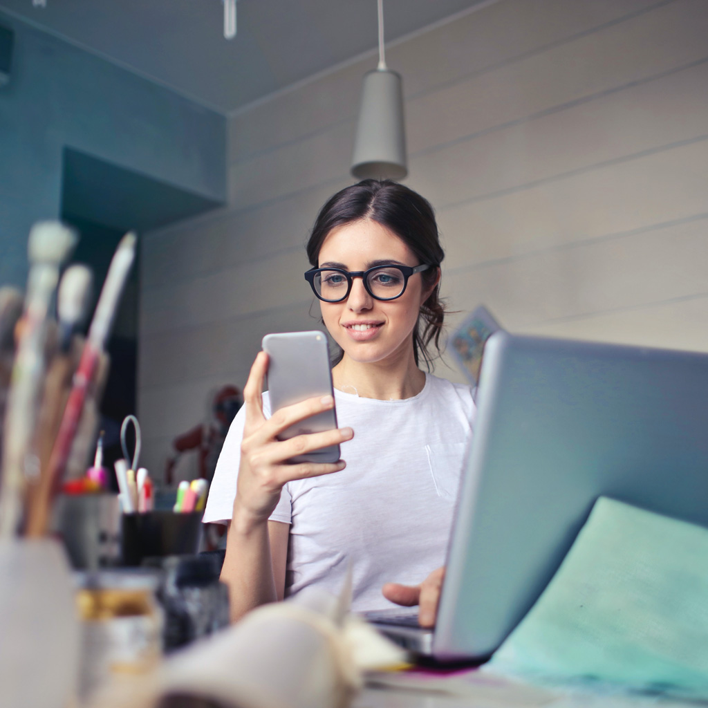 Une jeune entrepreneuse regardant son smartphone en souriant